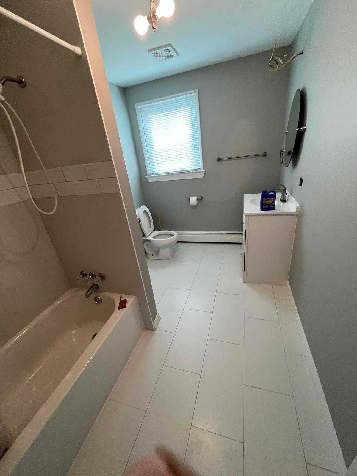 Completed bathroom renovation with modern gray paint and professional finish