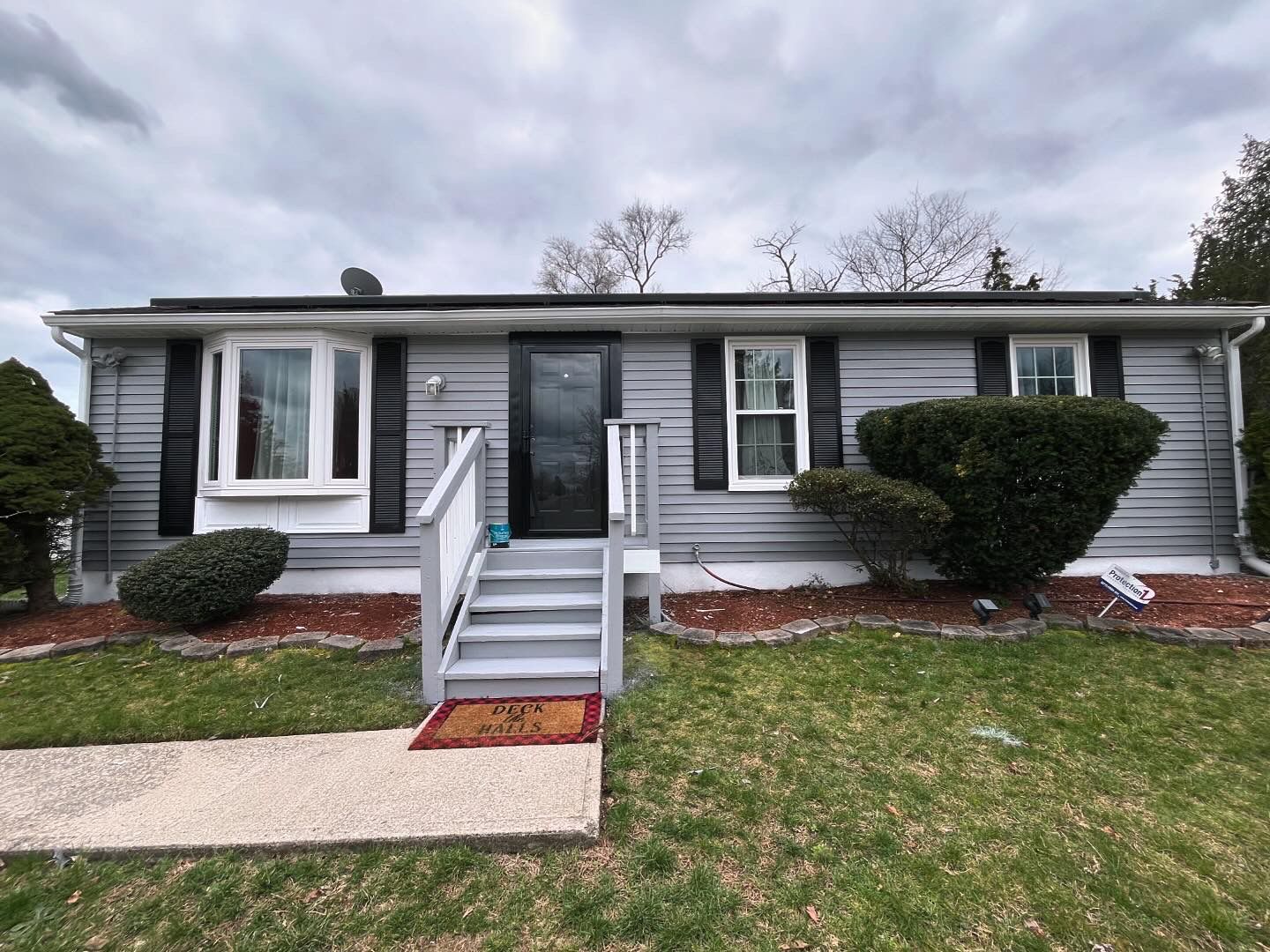 Freshly painted house exterior with gray siding and black shutters